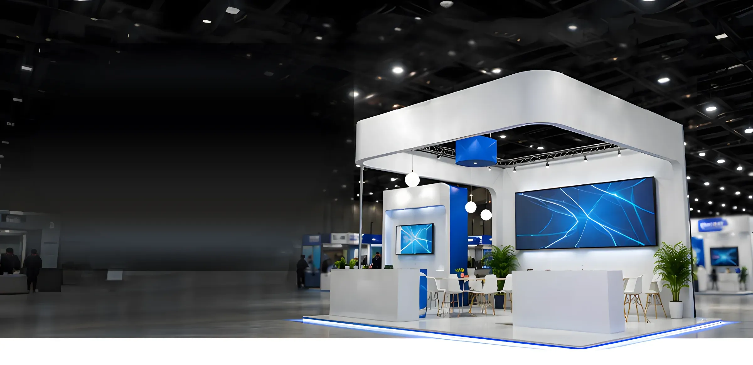 Illuminated white exhibition stall with blue LED screens on a large trade-show floor